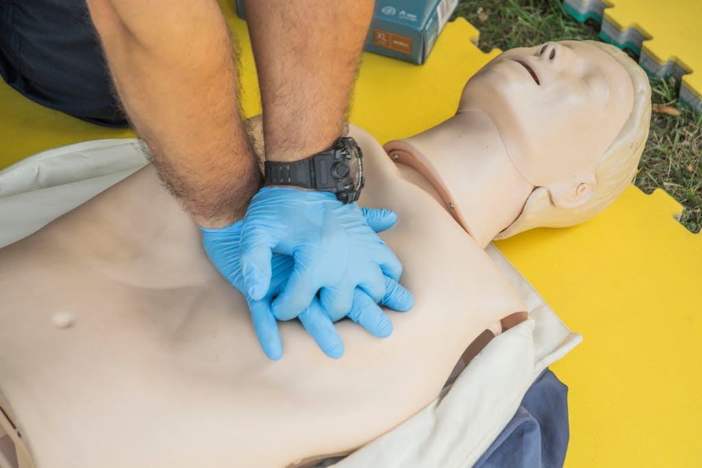 Close-up of hands performing CPR on a manikin for first aid training.